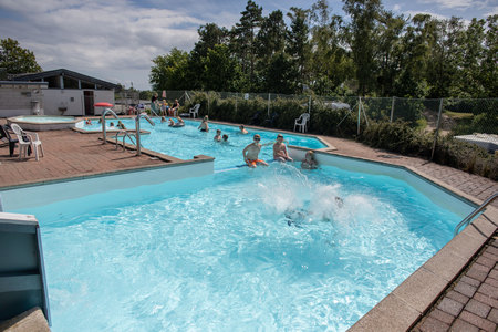 Swimmingpool med børnebassin, et stort bassin - og et bassin med vandrutchebane.